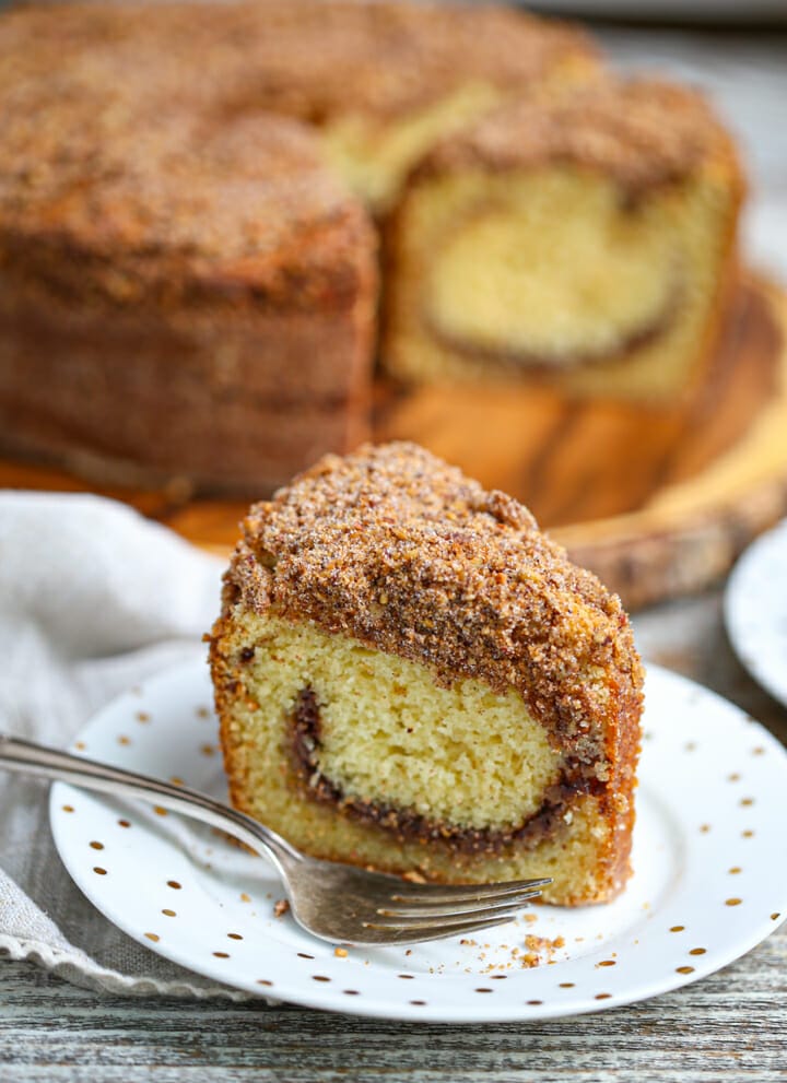 A serving of Sour Cream Coffee Cake with cinnamon nut topping on a plate with a fork.